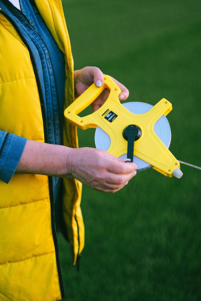 A Person Holding a Yellow Farm Tool